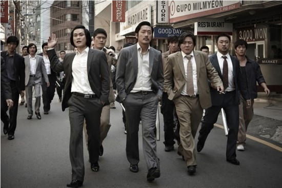 A group of suited men walking down a city street